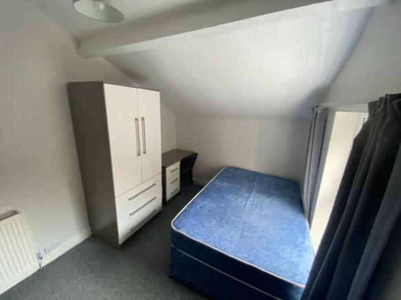 Cozy double bedroom featuring a comfortable bed...