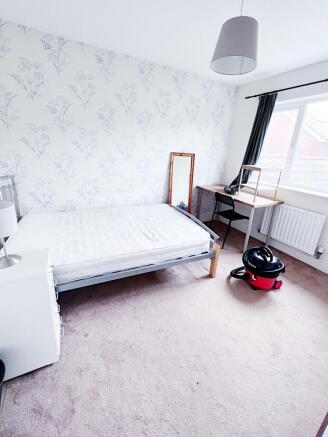 Bright, simply furnished bedroom with a double ...