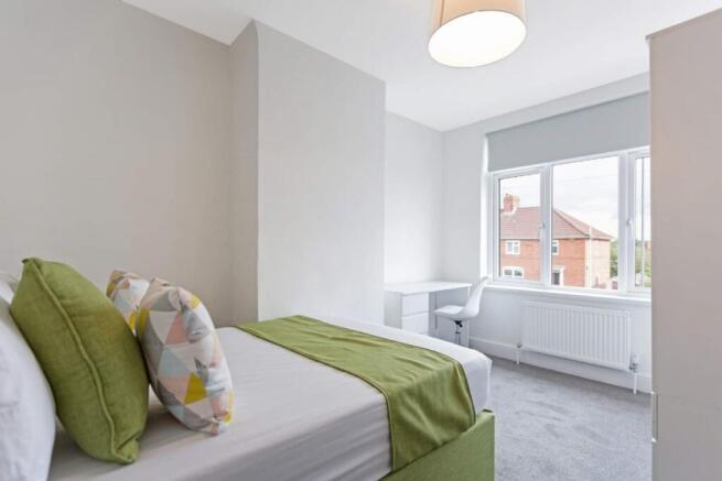 A bright and inviting double bedroom featuring ...