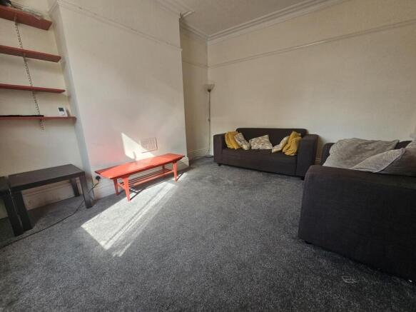 A spacious and neatly maintained living room fe...