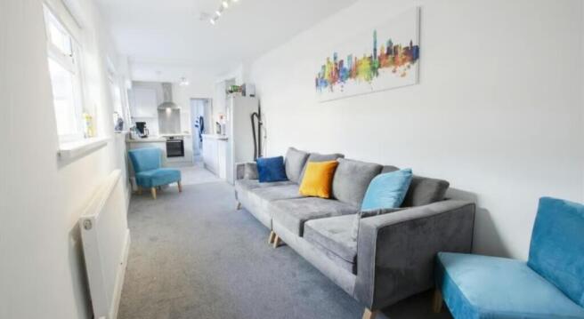 A bright and tidy living room featuring a comfo...