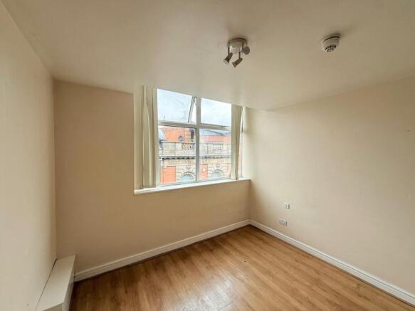 A bright and tidy empty single bedroom featurin...