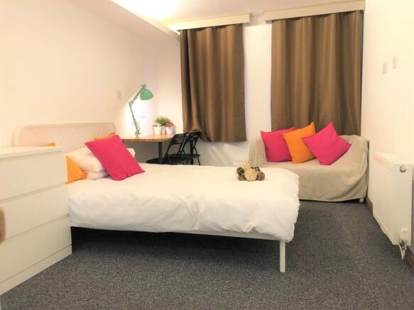 Bright and cozy single bedroom featuring a neat...