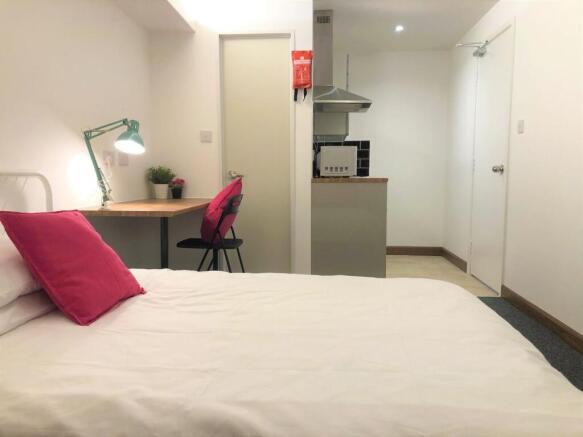 A neat and cozy single bedroom featuring a comf...