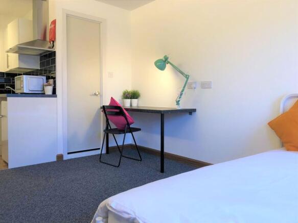 A bright and tidy single bedroom featuring a co...