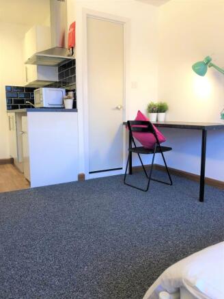 A neat and functional student bedroom featuring...