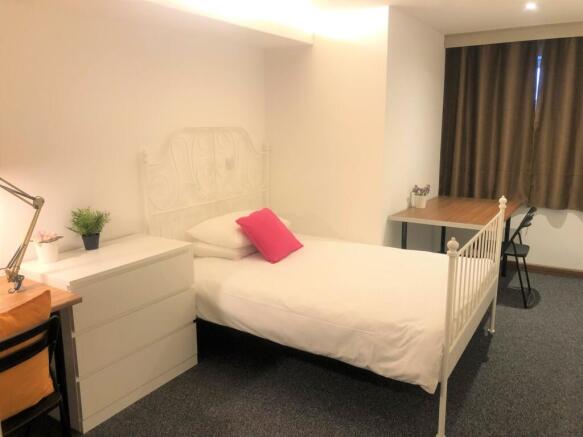 A bright and tidy single bedroom featuring a wh...