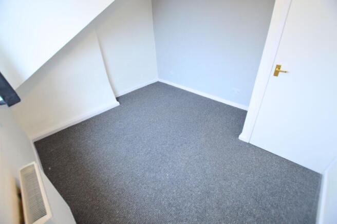 A clean and freshly carpeted small room with ne...