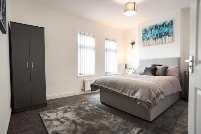 A bright and inviting master bedroom featuring ...