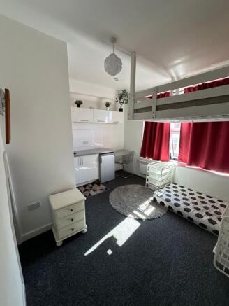 A compact, well-lit student room featuring a lo...