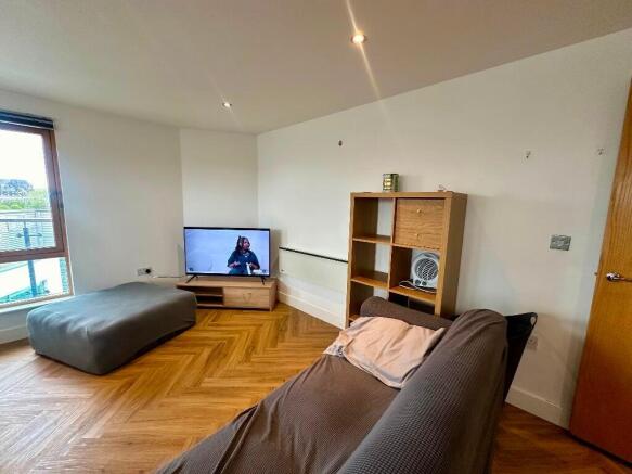 A modern living room featuring warm wooden floo...