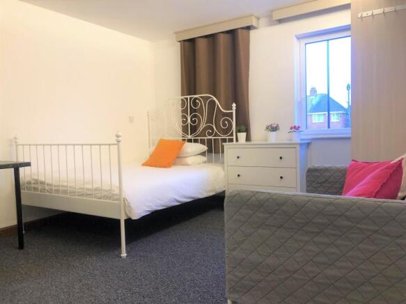 Bright and tidy bedroom featuring a white metal...