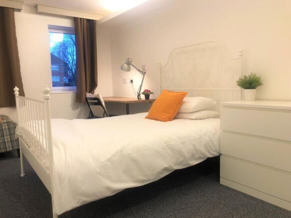 Bright and cozy single bedroom featuring a neat...