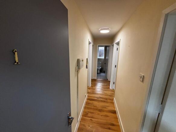 A bright, clean bathroom with a toilet and wind...