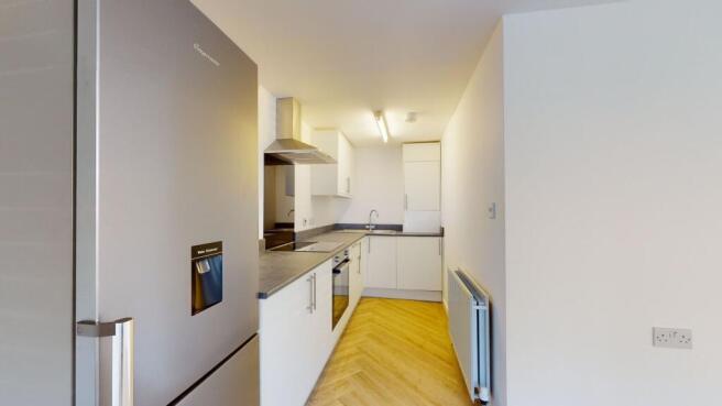 A modern, clean kitchen featuring white cabinet...
