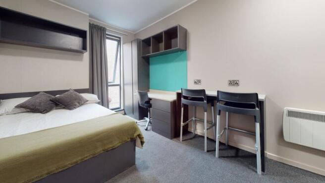 A clean and modern student room featuring a com...
