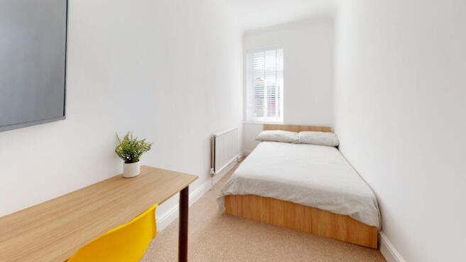A bright and airy double bedroom featuring a co...