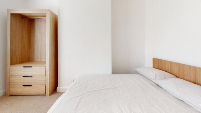 A neatly presented bedroom showcasing a comfort...