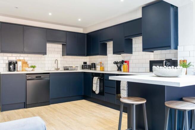 Modern kitchen with sleek navy blue cabinets, w...