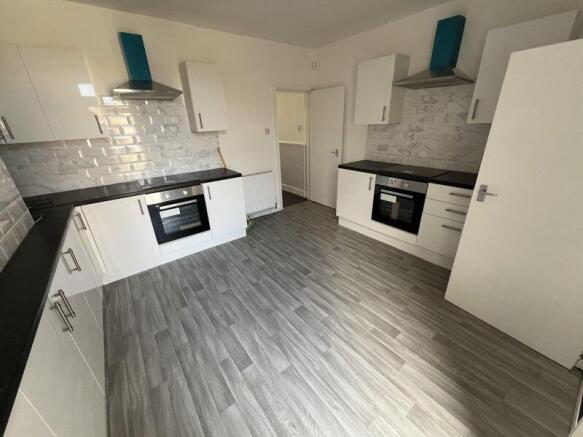 Bright and modern kitchen featuring dual oven s...