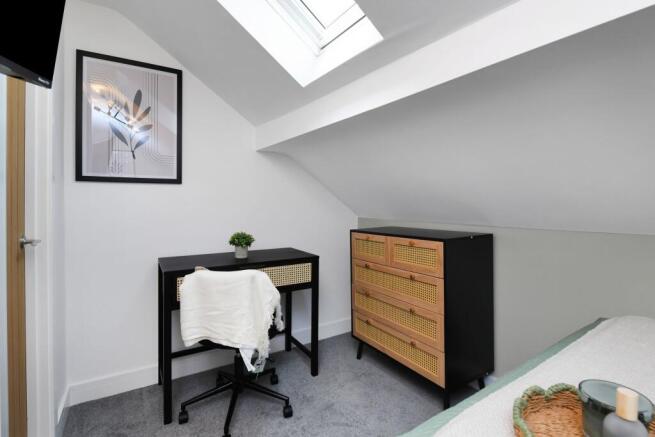 A bright and tidy bedroom featuring a modern de...