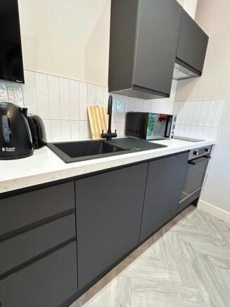 Modern kitchen with sleek dark cabinetry, a bla...