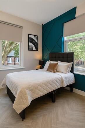 Bright and modern master bedroom featuring a la...