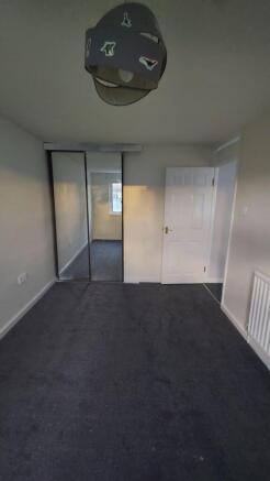 A well-maintained bedroom featuring a mirrored ...