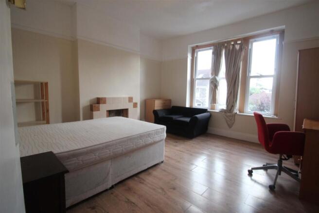 Spacious double bedroom featuring large windows...
