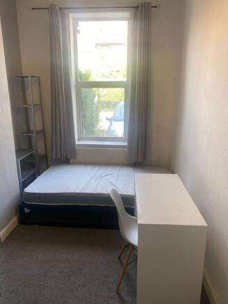 A cozy and bright single bedroom with a large w...
