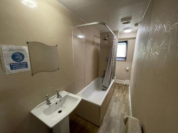 A clean, functional bathroom featuring a bathtu...