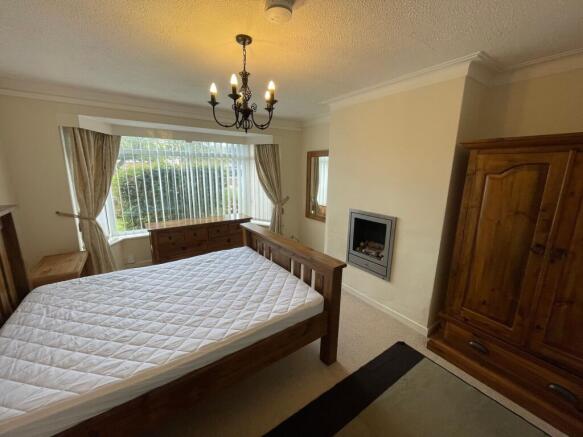 A well-maintained bedroom featuring a large win...