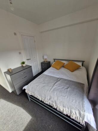 A modern, neatly presented double bedroom featu...