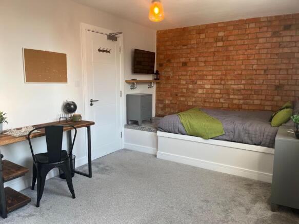 A modern, well-lit bedroom featuring a comforta...