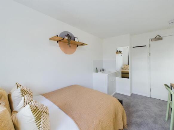 A bright and inviting double bedroom with styli...