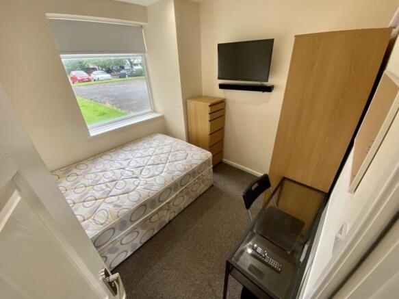 A bright and tidy double bedroom featuring mode...