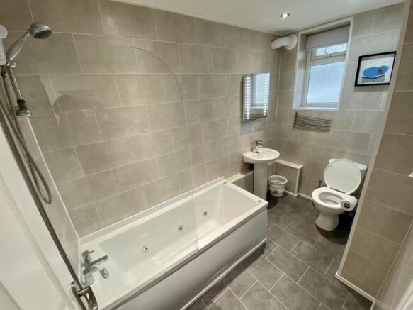 A spacious and modern bathroom featuring a rela...