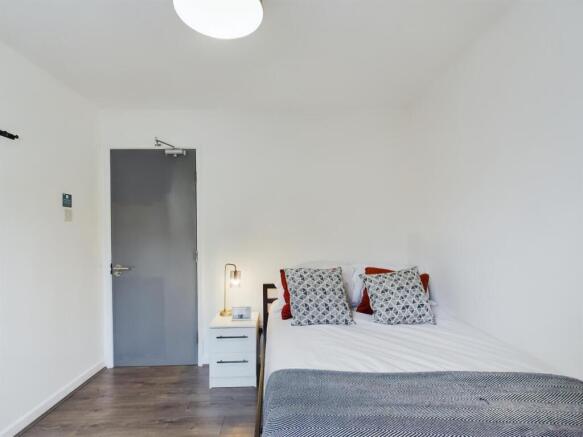 A bright and tidy double bedroom featuring a co...