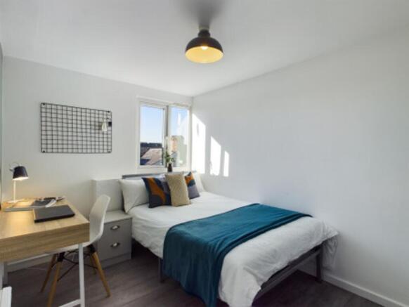 A bright and inviting double bedroom with moder...