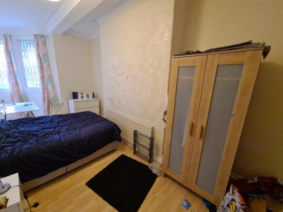 A cozy bedroom featuring a neatly made bed plac...