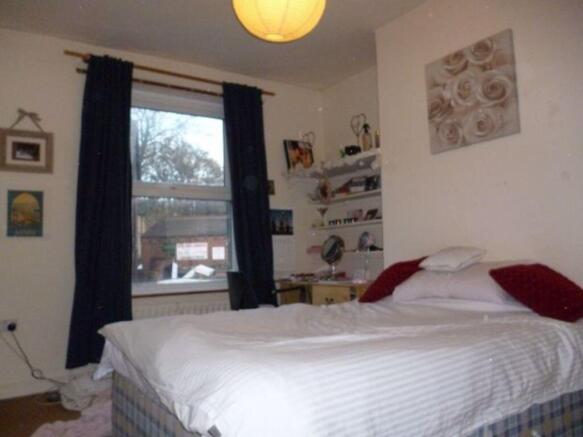 A spacious master bedroom featuring a large bed...