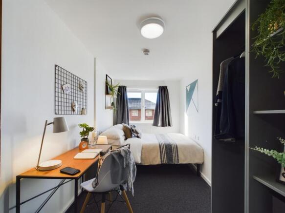 A bright and spacious double bedroom with a sty...