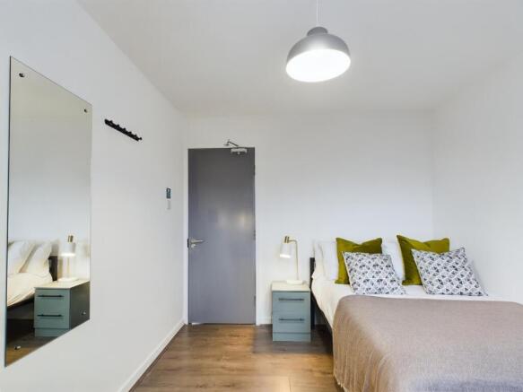 A bright and clean double bedroom featuring sty...