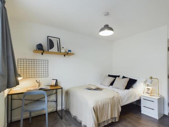 A bright and tidy double bedroom featuring a co...