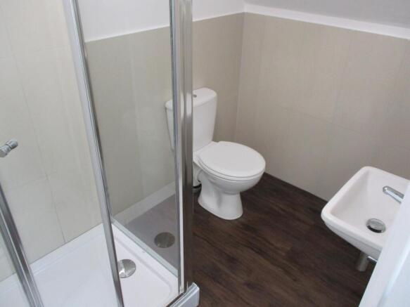 A clean, modern bathroom featuring a shower enc...