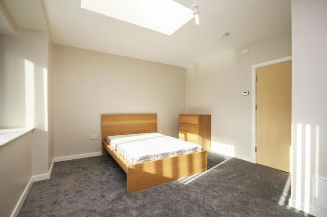 A bright and spacious double bedroom with moder...