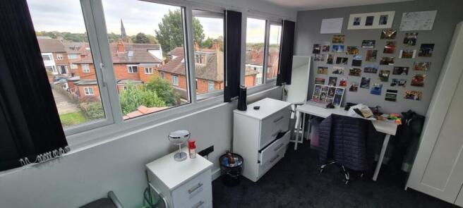 A clean and well-lit bedroom with large windows...