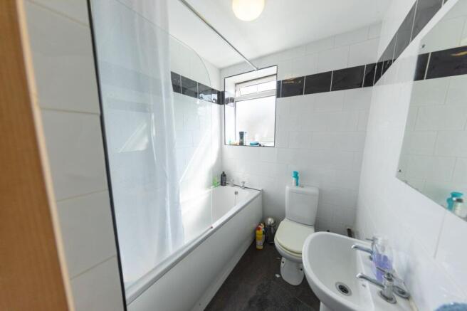 Bright and clean bathroom with a bathtub, a sma...