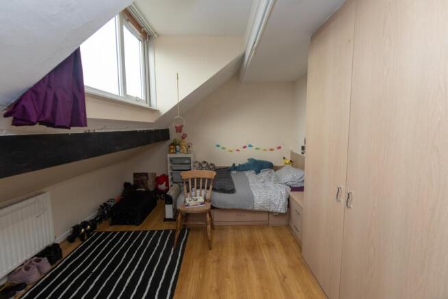 Cozy student bedroom with a sloped ceiling, fea...