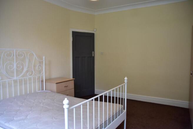 A bright and simple double bedroom featuring a ...